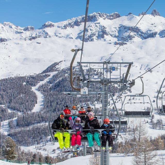 Famille sur un télésiège permettant d'accéder sur les hauteurs du domaine skiable