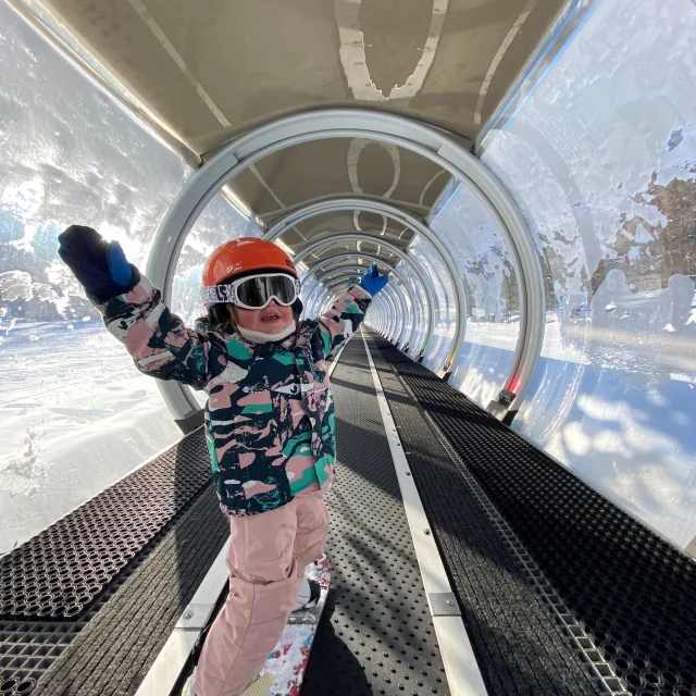 Petite fille apprenant à faire du snowboard